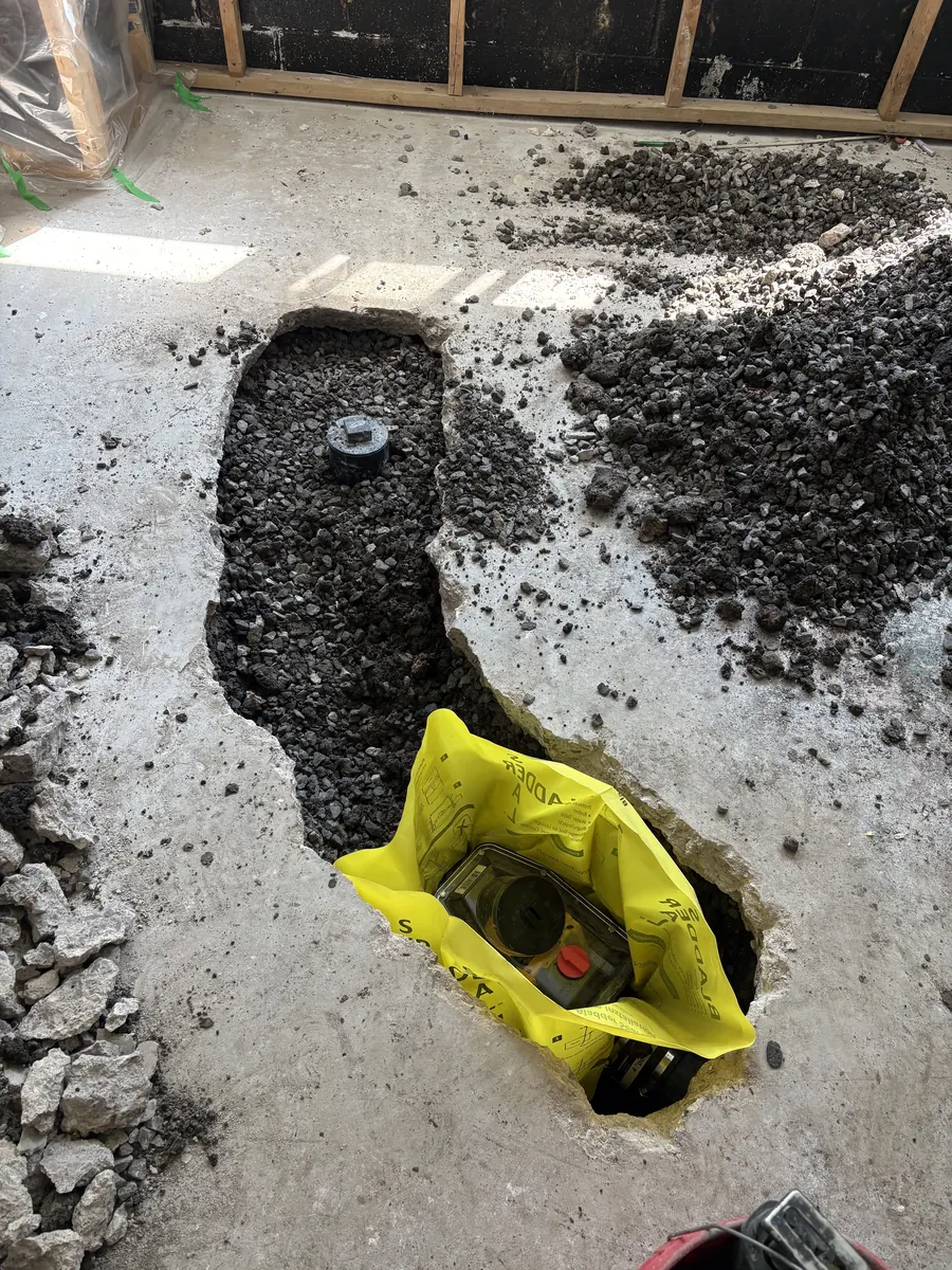 Basement floor opened at the main sewer line for a backwater valve installation
