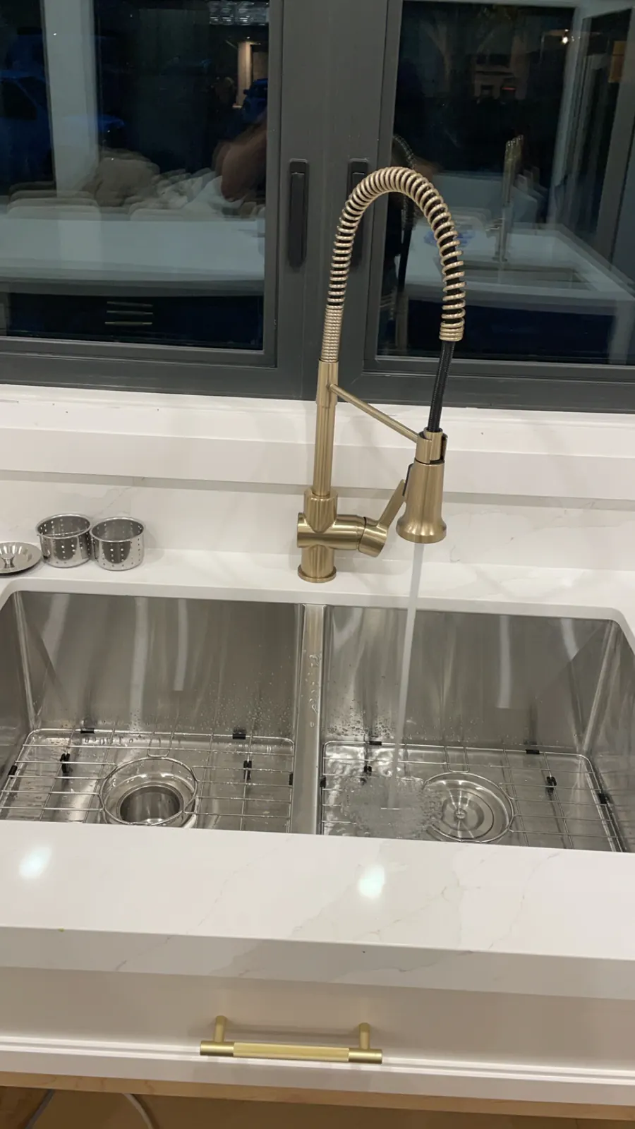 Brushed brass pull-down kitchen faucet on a stainless double sink
